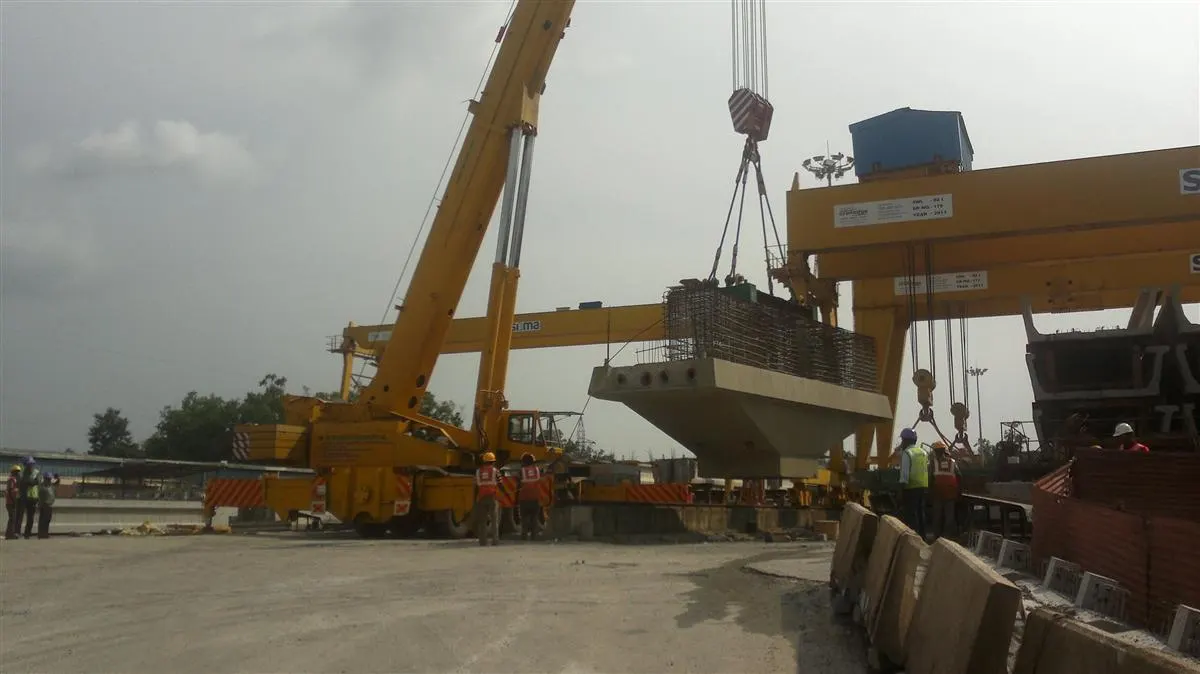 Mobile crane lifting a precast concrete girder on site