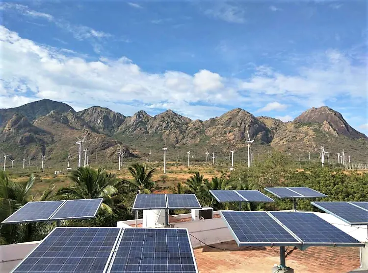 Rooftop solar installation with wind farm backdrop
